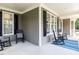 Welcoming front porch with comfortable rocking chairs, and stylish blue striped rug at 709 Skymont Dr, Holly Springs, NC 27540