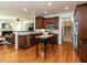 Spacious kitchen with dark wood cabinets, stainless steel appliances, and hardwood floors at 709 Skymont Dr, Holly Springs, NC 27540