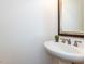 Cozy powder room with pedestal sink, framed mirror, and neutral decor at 709 Skymont Dr, Holly Springs, NC 27540