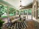 Relaxing screened-in porch with comfortable seating, ceiling fan, and views of the lush backyard at 709 Skymont Dr, Holly Springs, NC 27540