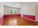 Bright bedroom featuring hardwood floors, white upper walls, red lower walls, and one window at 7620 Harps Mill Rd, Raleigh, NC 27615