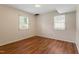 Bright bedroom with hardwood floors, neutral walls, and natural light from the two windows at 7620 Harps Mill Rd, Raleigh, NC 27615