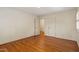Bedroom with hardwood floors, white walls, and open doorways to additional rooms at 7620 Harps Mill Rd, Raleigh, NC 27615