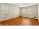 Bedroom with hardwood floors, white walls, two windows with shutters, and neutral colors at 7620 Harps Mill Rd, Raleigh, NC 27615