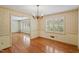 Light-filled dining room featuring hardwood floors, chandelier, and decorative wallpaper at 7620 Harps Mill Rd, Raleigh, NC 27615