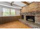 Living room fireplace featuring a brick surround and stone hearth at 7620 Harps Mill Rd, Raleigh, NC 27615