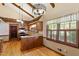 Cozy kitchen features wood cabinets, granite counters, stainless steel appliances, a window, and wood beams at 7620 Harps Mill Rd, Raleigh, NC 27615