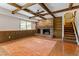 Living room featuring a brick fireplace, wood floors, and exposed beam ceiling at 7620 Harps Mill Rd, Raleigh, NC 27615