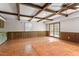 Living room with exposed beam ceiling, wood floors, and french doors at 7620 Harps Mill Rd, Raleigh, NC 27615