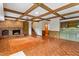 Living room featuring a brick fireplace, wood floors, wet bar and cabinets at 7620 Harps Mill Rd, Raleigh, NC 27615