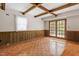 Living room with wood floors, exposed beam ceiling, and french doors at 7620 Harps Mill Rd, Raleigh, NC 27615