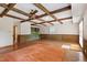Living room with exposed beam ceiling, wood floors, wet bar and cabinets at 7620 Harps Mill Rd, Raleigh, NC 27615