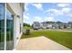 View of backyard and neighborhood with concrete patio and green grass at 80 Nailsworth St, Angier, NC 27501