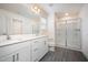 Modern bathroom features double sinks, gray plank flooring, and glass-enclosed walk-in shower at 80 Nailsworth St, Angier, NC 27501