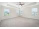 Spacious bedroom featuring a tray ceiling, a ceiling fan, and three large windows at 80 Nailsworth St, Angier, NC 27501