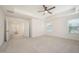 Bright main bedroom boasting soft carpet, neutral walls, and ample natural light from two large windows at 80 Nailsworth St, Angier, NC 27501