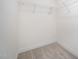 Unfinished walk-in closet with basic wire shelving and plush neutral carpet at 80 Nailsworth St, Angier, NC 27501