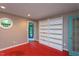 Bedroom with red floors, built in shelving, and glass door to an outdoor porch area at 820 Runnymede Rd, Raleigh, NC 27607