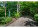Unique exterior with lush landscaping, gravel driveway, and modern design elements at 820 Runnymede Rd, Raleigh, NC 27607