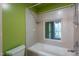 Bright bathroom featuring a tiled shower and tub combination with a window at 820 Runnymede Rd Rd, Raleigh, NC 27607