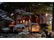 Unique home exterior nestled among trees, featuring balcony and warm interior lighting at 820 Runnymede Rd Rd, Raleigh, NC 27607