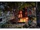 Charming exterior view of home with wood accents and lush landscaping at night at 820 Runnymede Rd Rd, Raleigh, NC 27607