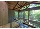 Unique interior architectural details with wood ceiling beams and large windows overlooking lush greenery at 820 Runnymede Rd Rd, Raleigh, NC 27607