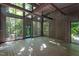 Spacious living room with high ceilings, wood walls, and a wall of glass windows at 820 Runnymede Rd Rd, Raleigh, NC 27607