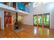 Spacious living room featuring a wood burning fireplace, soaring ceilings, and views of the surrounding trees at 820 Runnymede Rd Rd, Raleigh, NC 27607