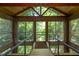 Sunroom with wooden ceiling beams and natural light provided by many windows at 820 Runnymede Rd Rd, Raleigh, NC 27607