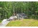 Garage and open field of a house amidst tall trees, with a playhouse for children at 88 Priscilla Ln, Fuquay Varina, NC 27526