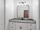 Bathroom with a granite countertop, a modern faucet, and a decorative, framed mirror at 88 Priscilla Ln, Fuquay Varina, NC 27526