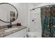Bathroom featuring a granite vanity, a round mirror, and a tiled shower with a floral curtain at 88 Priscilla Ln, Fuquay Varina, NC 27526