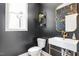 Modern powder room with white vessel sink, dark walls, gold fixtures and decoratively framed mirror at 88 Priscilla Ln, Fuquay Varina, NC 27526