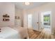 This sun-filled bedroom features wood floors and a door leading to an adjacent room at 88 Priscilla Ln, Fuquay Varina, NC 27526