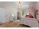 Bright bedroom with playful flower wall accents, wood floors, and a delightful decorative canopy bed at 88 Priscilla Ln, Fuquay Varina, NC 27526