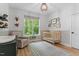 Wood-floored Bedroom featuring a neutral palette, crib, accent decorations, and a large picture window at 88 Priscilla Ln, Fuquay Varina, NC 27526