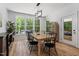 Open dining room with many windows, wooded outdoor views and modern light fixture at 88 Priscilla Ln, Fuquay Varina, NC 27526