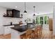 Modern kitchen with a large island, black countertops, stainless steel appliances, and stylish pendant lights at 88 Priscilla Ln, Fuquay Varina, NC 27526