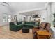 Inviting living room featuring a large green sofa, hardwood floors, and ample natural light at 88 Priscilla Ln, Fuquay Varina, NC 27526
