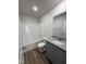 Clean bathroom featuring a shower-tub combo, granite vanity and wood-look floors at 91 Oakfield Trace Dr, Four Oaks, NC 27524