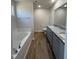 Bathroom with double vanity, granite countertop, soaking tub, wood-look flooring and natural light at 91 Oakfield Trace Dr, Four Oaks, NC 27524
