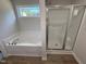Bright bathroom with soaking tub, shower, wood-look floors and natural light from a large window at 91 Oakfield Trace Dr, Four Oaks, NC 27524