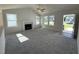 Bright living room featuring neutral carpet, a fireplace, large windows, and an open doorway at 91 Oakfield Trace Dr, Four Oaks, NC 27524