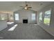 Bright living room featuring neutral carpet, a fireplace, large windows, and views of the kitchen area at 91 Oakfield Trace Dr, Four Oaks, NC 27524
