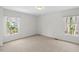 Bright bedroom with two windows providing natural light and neutral carpeting at 947 Manchester Dr, Cary, NC 27511