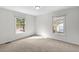 Simple, bright bedroom with two windows and neutral-colored carpet at 947 Manchester Dr, Cary, NC 27511
