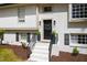 Close up view of a freshly painted white brick home with black front door at 947 Manchester Dr, Cary, NC 27511