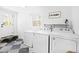 Bright laundry room with washer, dryer, freezer, and checkered tile floor at 947 Manchester Dr, Cary, NC 27511