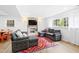 Cozy living room with grey couches, colorful rug, fireplace, and a TV on the wall at 947 Manchester Dr, Cary, NC 27511